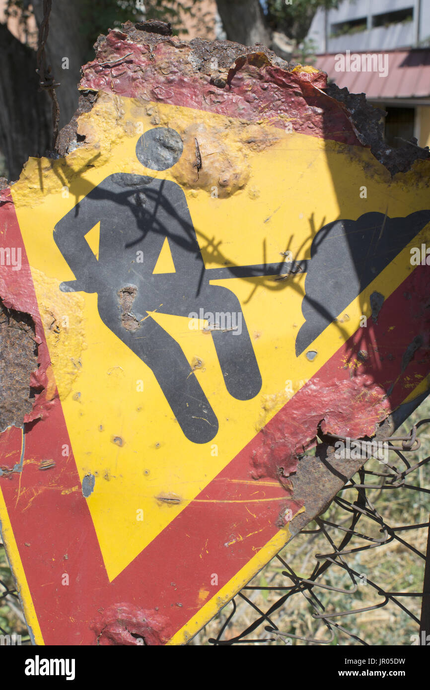 Vecchie e arrugginite strada segno del lavoro in corso Foto Stock