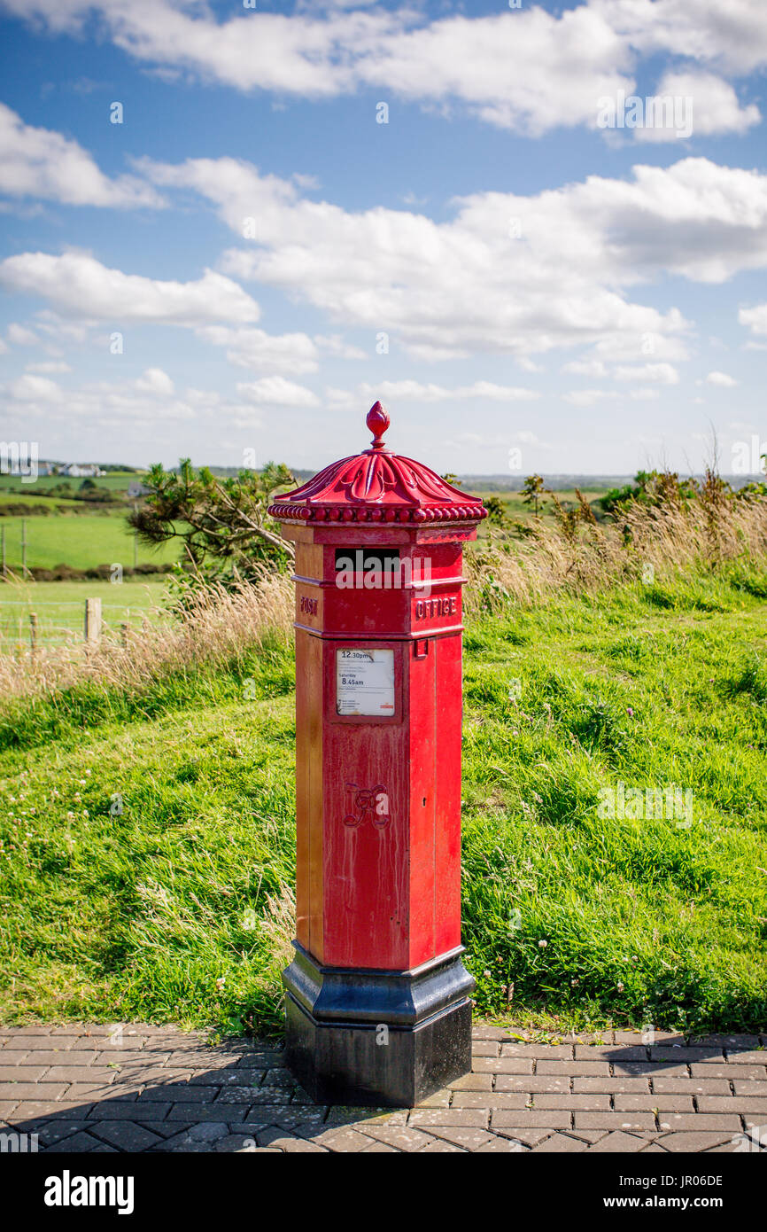 Rosso nella casella postale con un cielo estivo in background si trova presso il Selciato del gigante Bushmills Antrim Irlanda del Nord Foto Stock