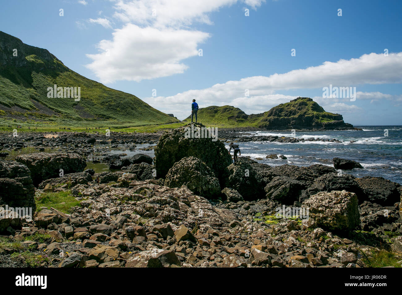 Irlanda del Nord Antrim Busmills Giant's Causeway - i turisti sono saliti sulla roccia di basalto per prendere selfies o in posa per la fotografia e ammirando Foto Stock