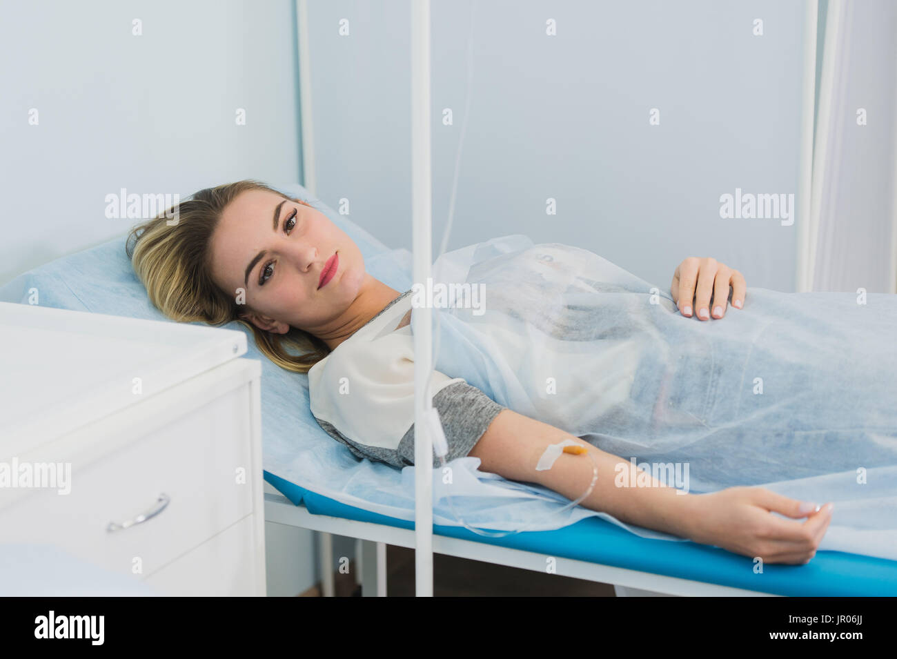 Donna sdraiata nel letto di ospedale e sorridente. Foto Stock