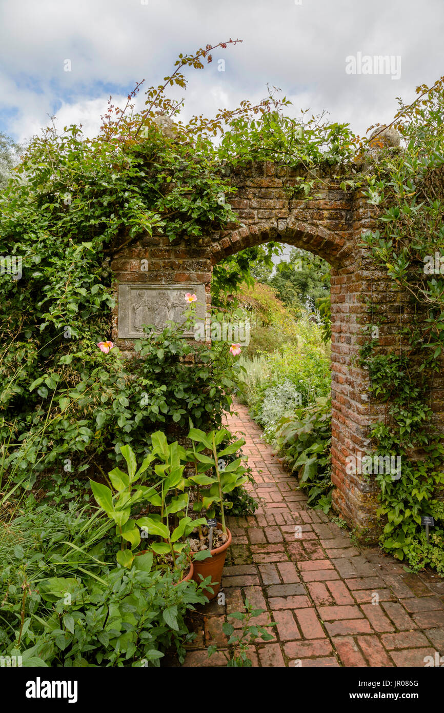 Vista invitante attraverso un rosso mattone gate verso il castello di Sissinghurst giardino, Kent, Inghilterra, Regno Unito. Foto Stock