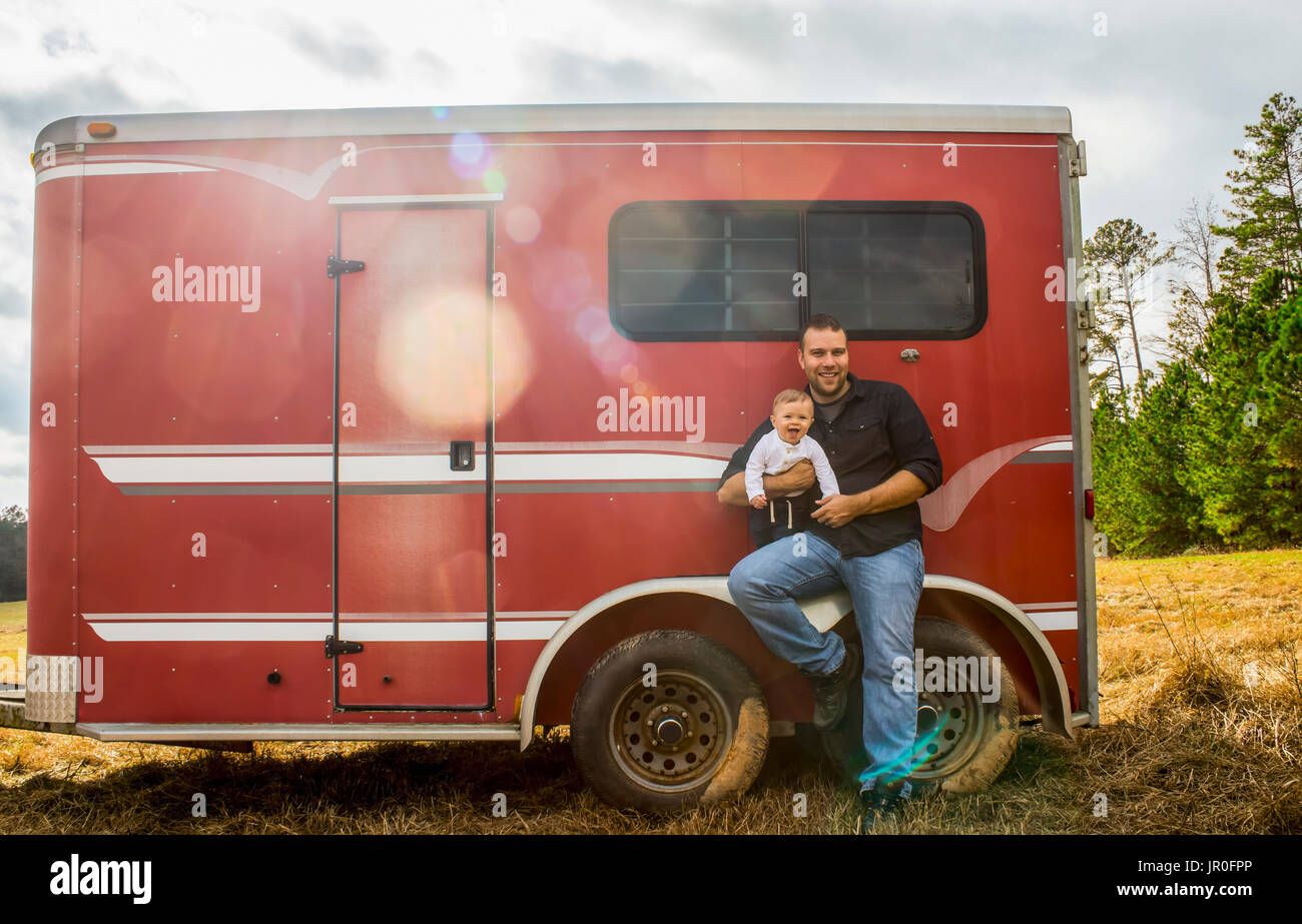 Un bambino ragazzo caucasico e suo padre sedersi sulla ruota e di un cavallo rosso rimorchio; Nuovo Hill, North Carolina, Stati Uniti d'America Foto Stock
