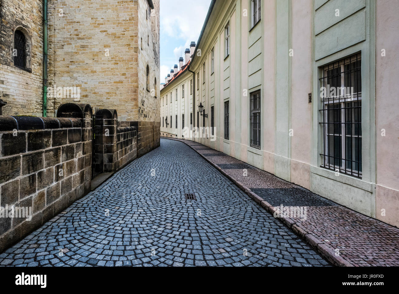 Stretta strada acciottolata tra edifici; Praga Cechia Foto Stock