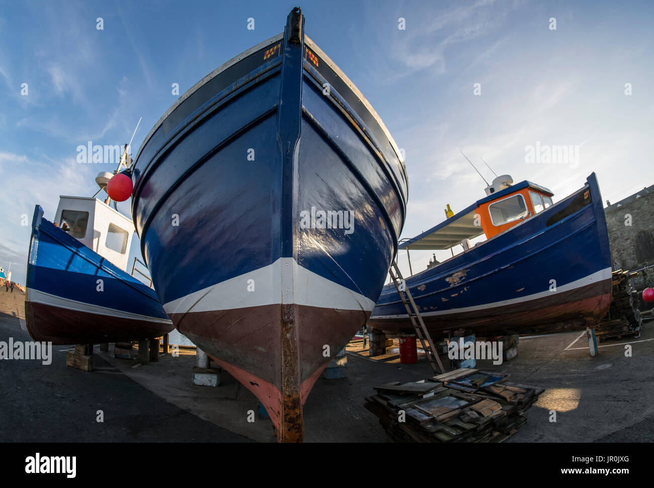 Basso angolo Vista della prua di una barca da pesca sulla riva per manutenzione; Seahouses, Northumberland, Inghilterra Foto Stock