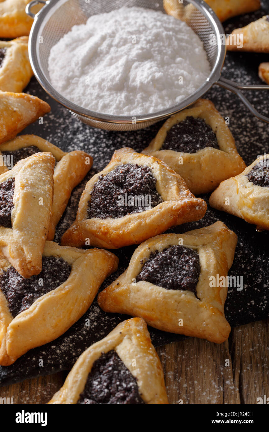 Hamantaschen cookie con un riempimento di papavero per celebrare la festa di Purim close-up su una tavola verticale. Foto Stock