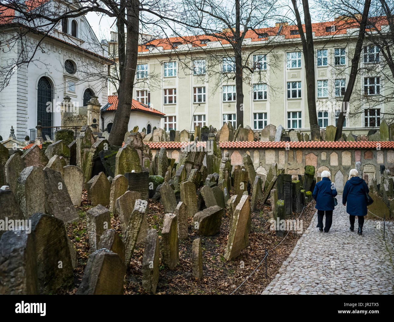 Due le donne anziane a piedi giù per un sentiero accanto a un antico cimitero ebraico di Praga, Repubblica Ceca Foto Stock