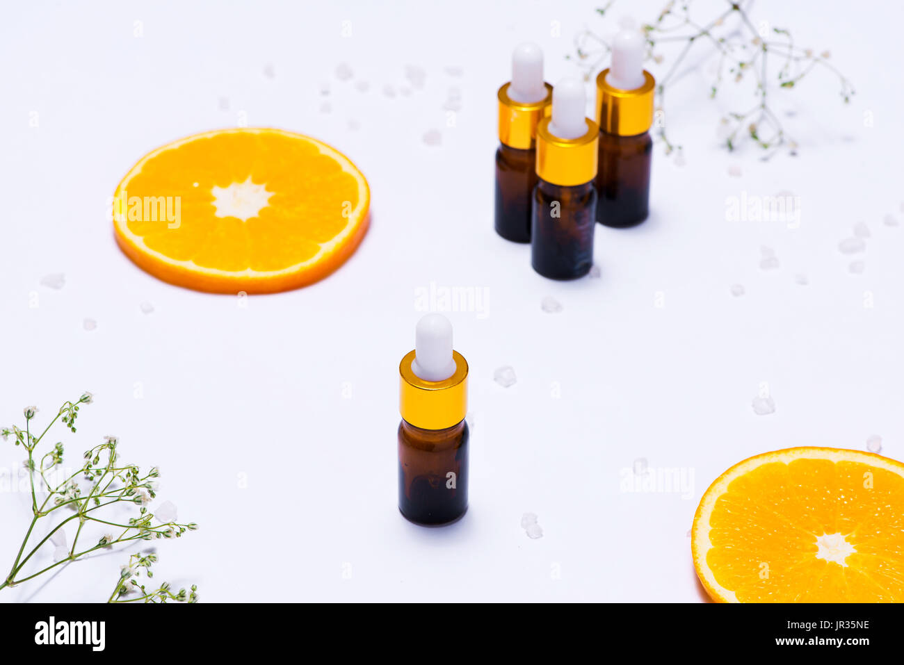 Il Branding mock-up. Olio essenziale naturale, bottiglia di cosmetici contenitori con fettine di arancia. Foto Stock
