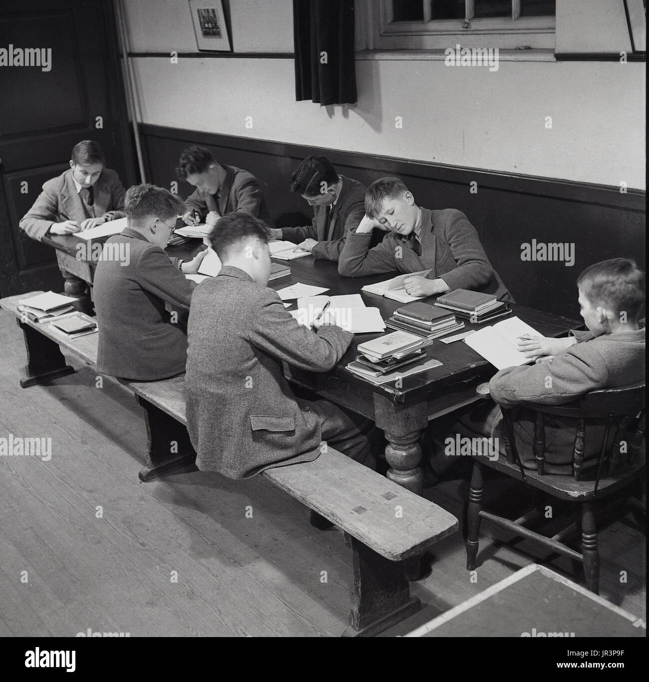 1948, Inghilterra, Regno Unito, foto storiche, mostra un gruppo di ragazzi in giacca e cravatte facendo ther prep o dopo la classe togther compiti ad un tavolo a Haileybury Publlic scuola, un tradizionale inglese boys' Boarding School. Foto Stock