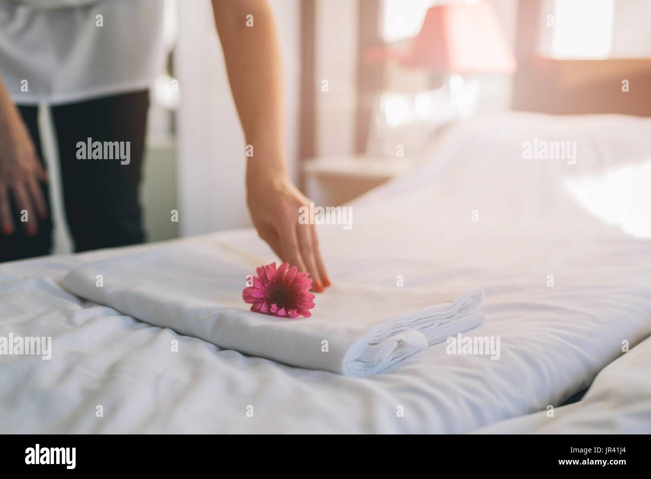 Hotel maid facendo servizio in camera. È lei che compongono i letti. Foto Stock