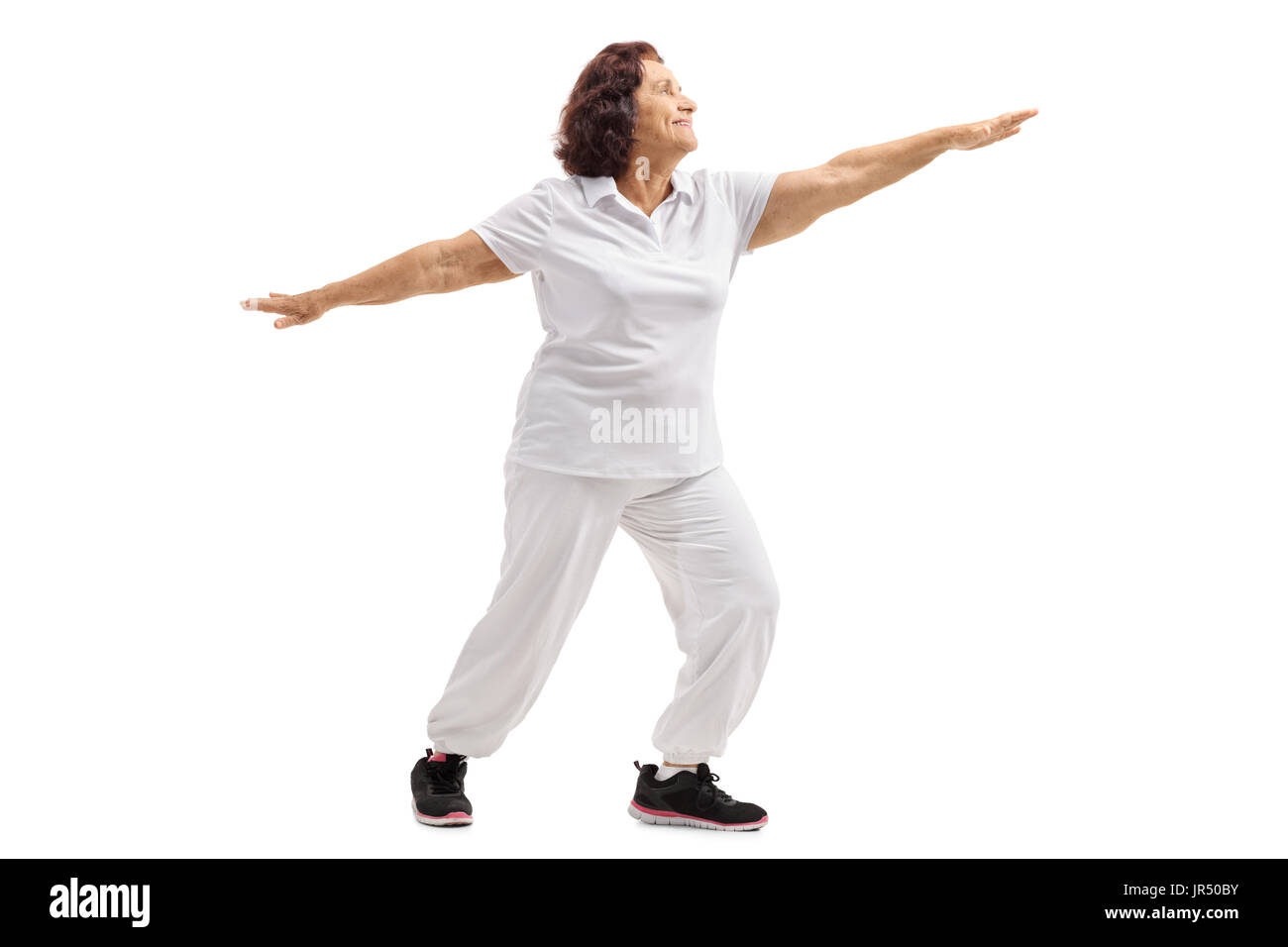 Lunghezza piena ripresa del profilo di una donna anziana a praticare yoga isolati su sfondo bianco Foto Stock