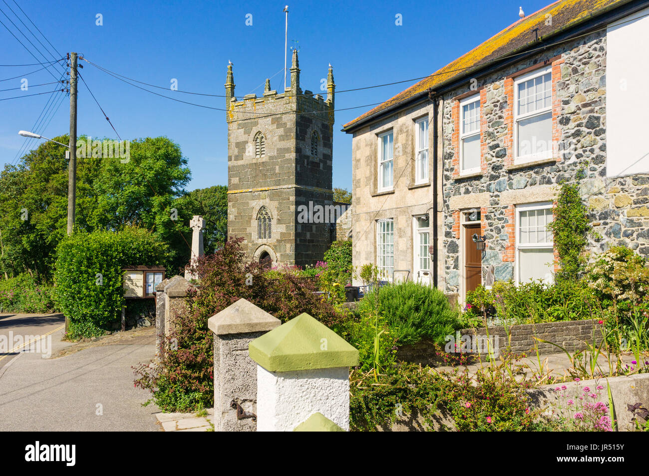 Fila di cottages e St Mellanus inglese chiesa di villaggio in villaggio Mullion sulla penisola di Lizard, Cornwall, Regno Unito Foto Stock