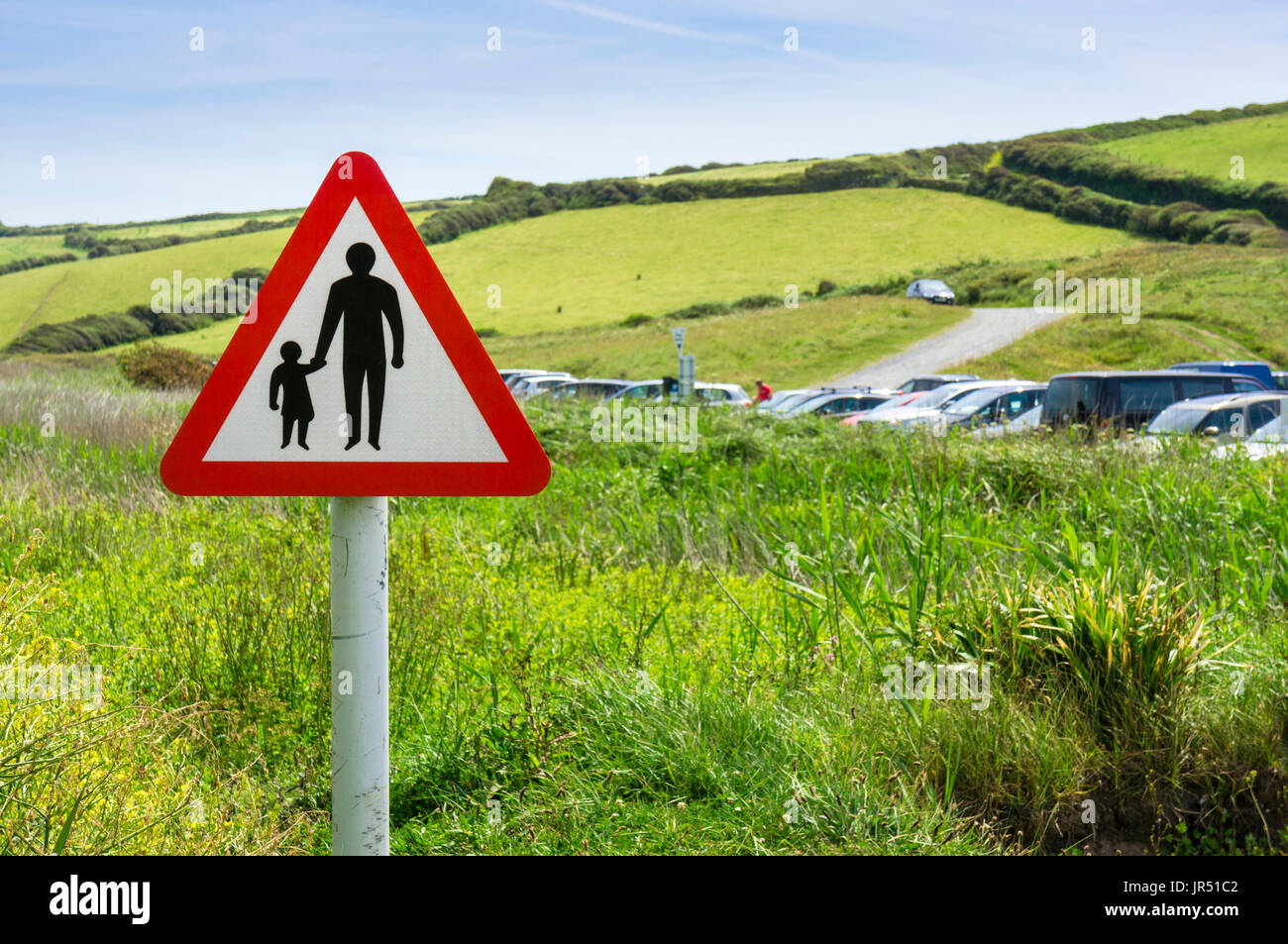 Cartello segnaletico per i pedoni che attraversano o camminano lungo la strada in campagna. Informazioni sulla sicurezza stradale triangolo rosso, Inghilterra, Regno Unito Foto Stock
