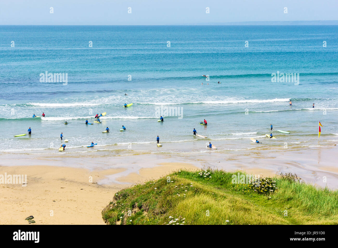 Scuola di surf con persone di imparare a navigare a Poldhu Cove UK Beach, Cornwall, Regno Unito Foto Stock