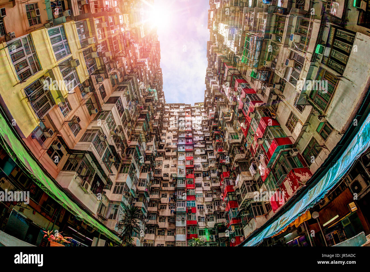 Nella tarda mattinata di picchi di sole attraverso il tetto di un affollato e blocco di alloggiamento di Hong Kong del vecchio quartiere residenziale di Quarry Bay. Con una popolazione o Foto Stock