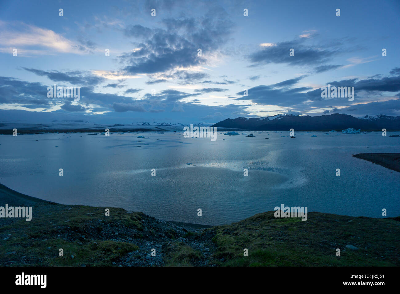 Islanda - Costa della laguna glaciale joekulsarlon con ghiaccio galleggiante floes a mezzanotte Foto Stock