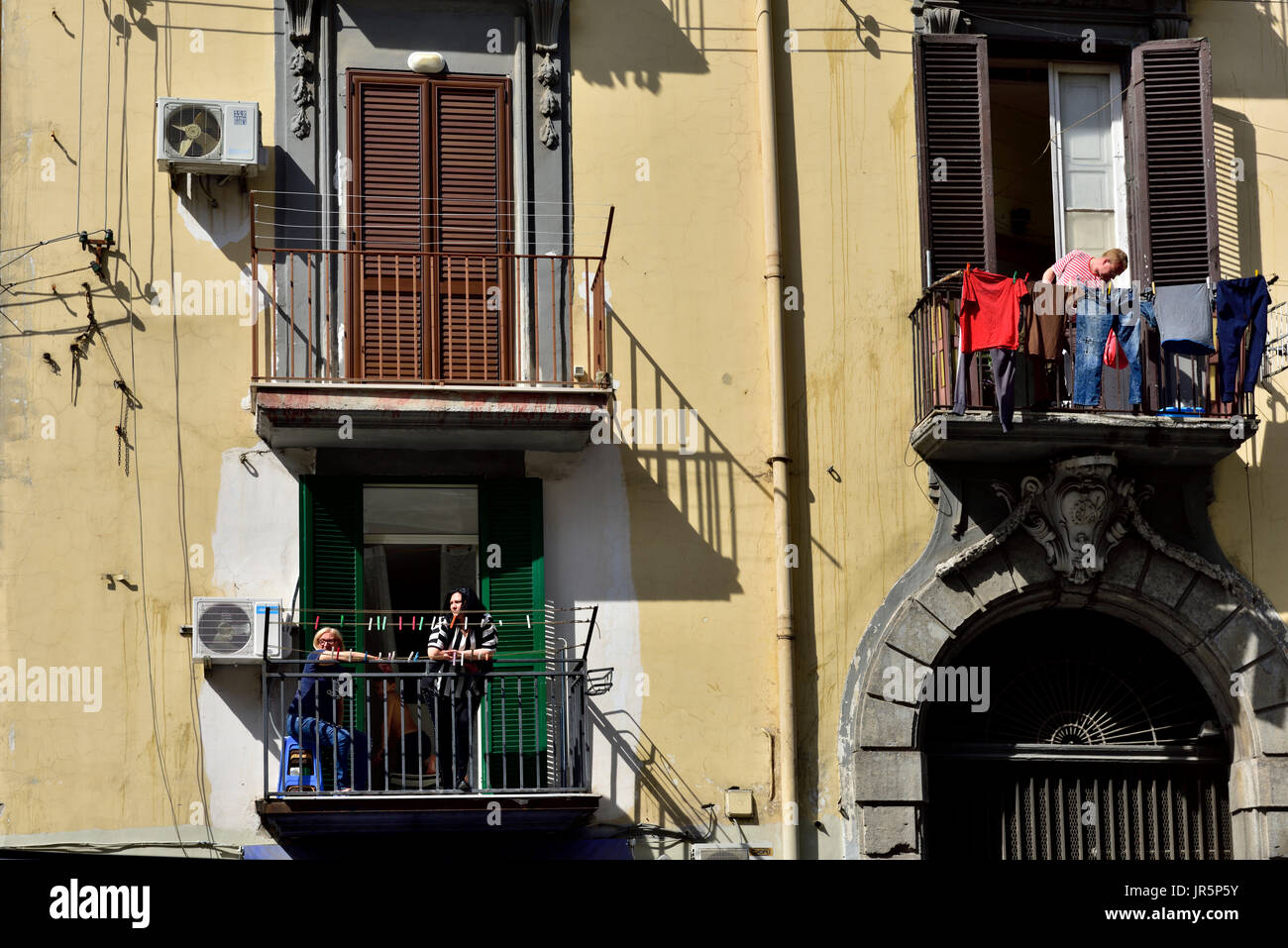 Edificio di appartamenti con persone che utilizzano e su ballconies, Napoli, Italia Foto Stock