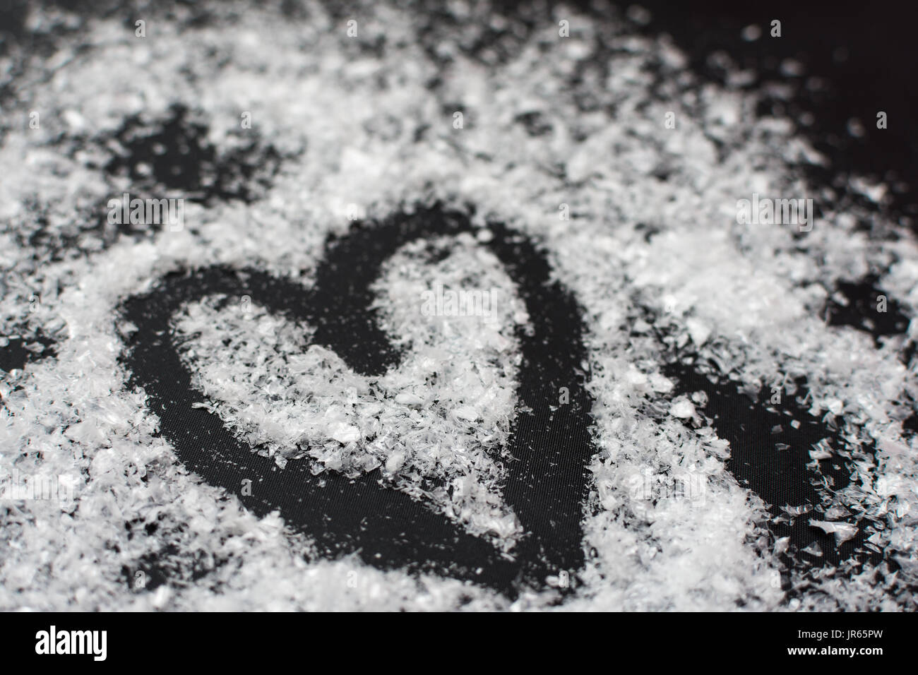 Natale forma di cuore disegnato su falsi neve su sfondo nero Foto Stock