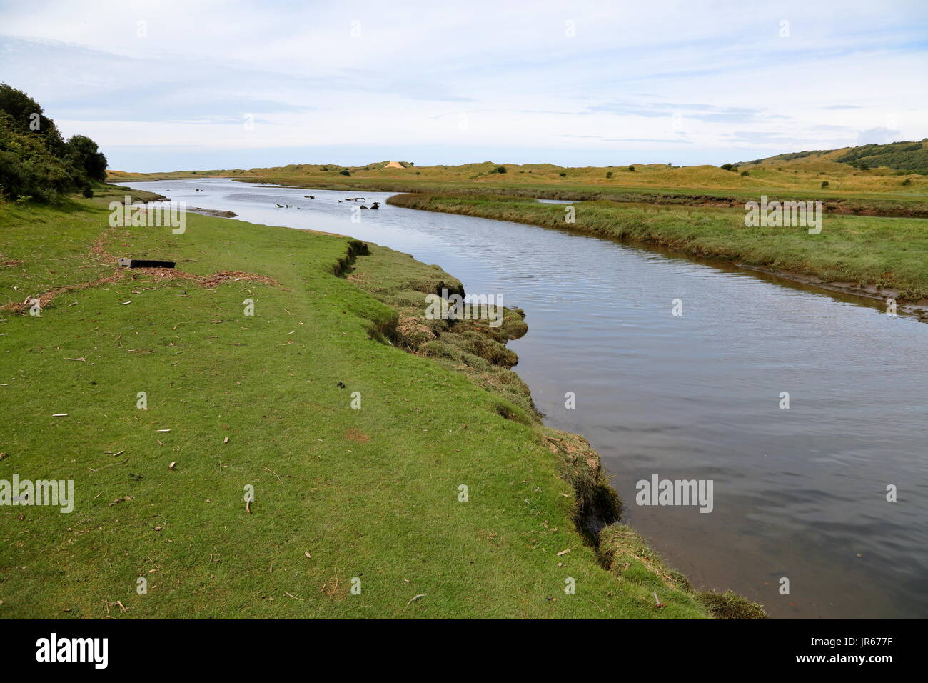 Il fiume Ogmore (Aberogwr) che scorre verso il mare con erba verde banche e profonda flowingn lenta acque. Foto Stock