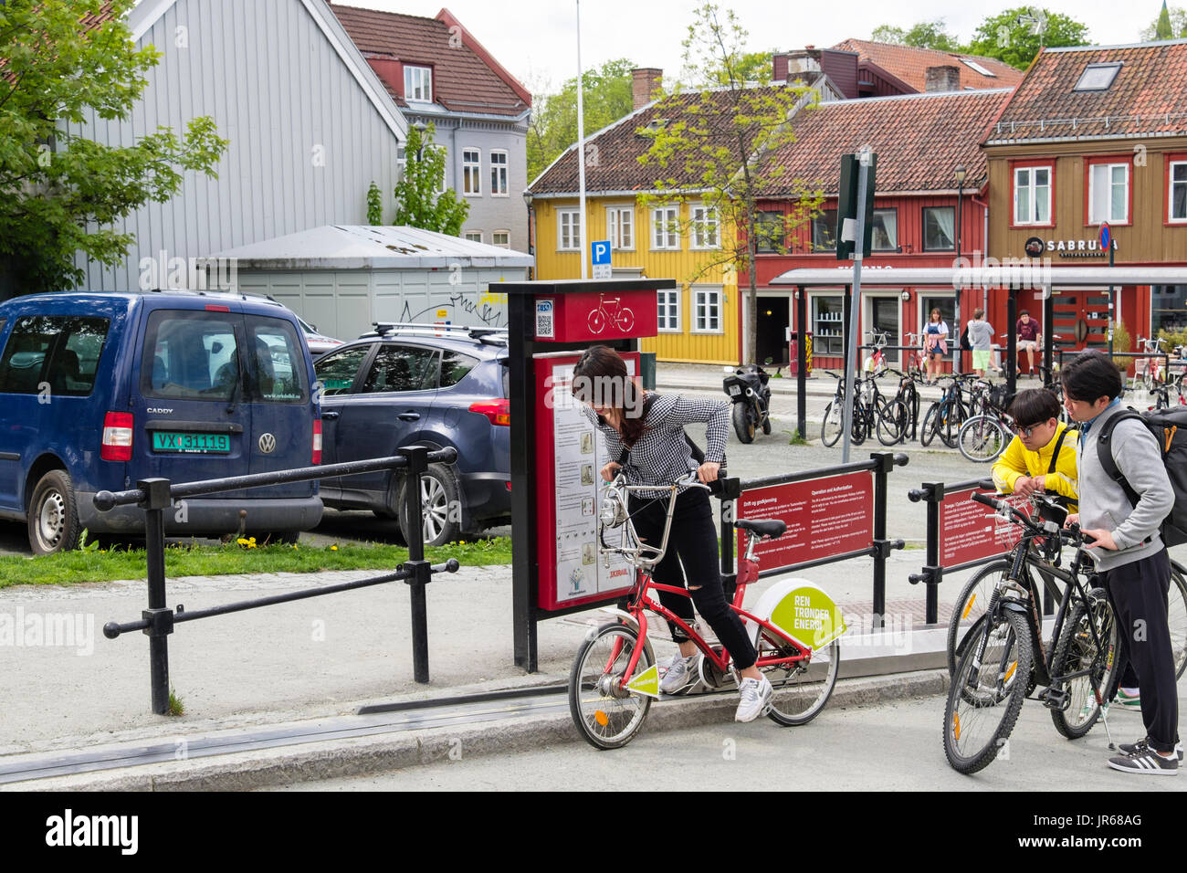 Persona in sella a una bicicletta utilizzando il sollevamento di bicicletta all'inizio nella città vecchia. Brubakken, Trondheim, Sør-Trøndelag, Norvegia e Scandinavia Foto Stock
