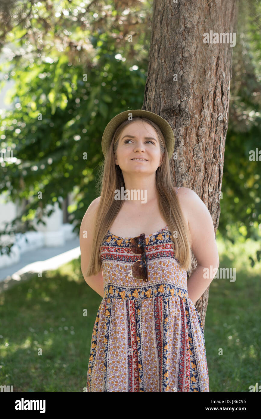 Ritratto di una donna sorridente appoggiato a un albero Foto Stock