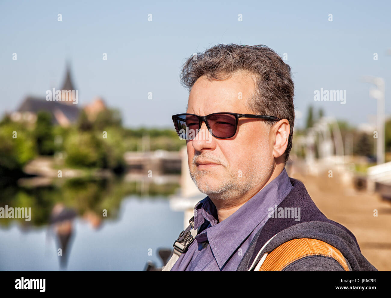 Ritratto di un uomo maturo in piedi da waterfront in estate Foto Stock