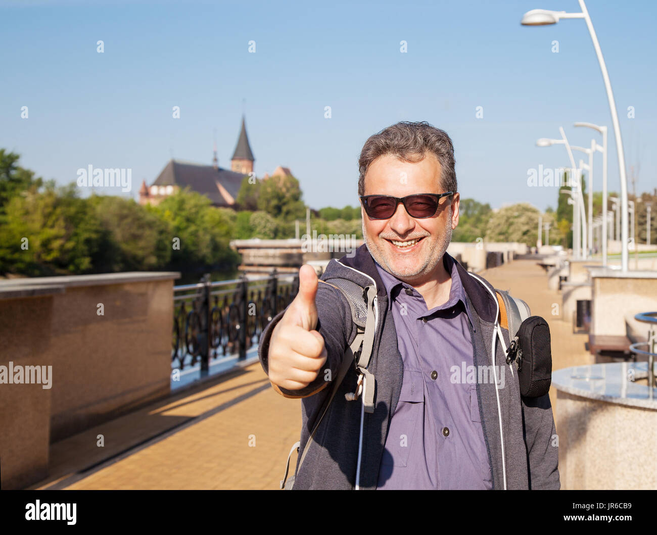 Ritratto di un uomo sorridente dando un pollice in alto Foto Stock