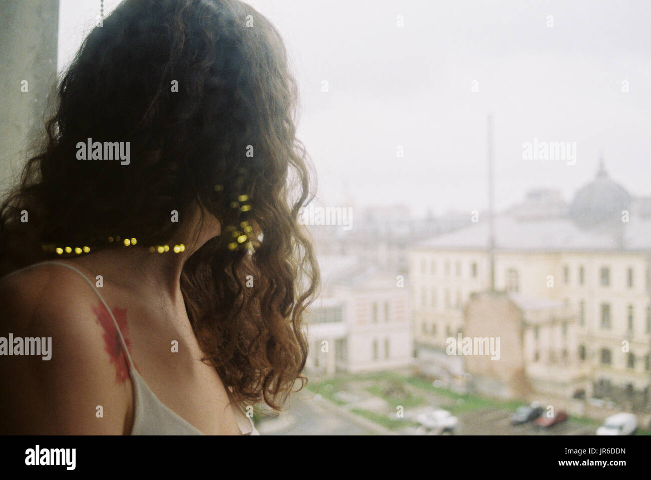 Donna che guarda fuori da una finestra, Bucarest, Romania Foto Stock