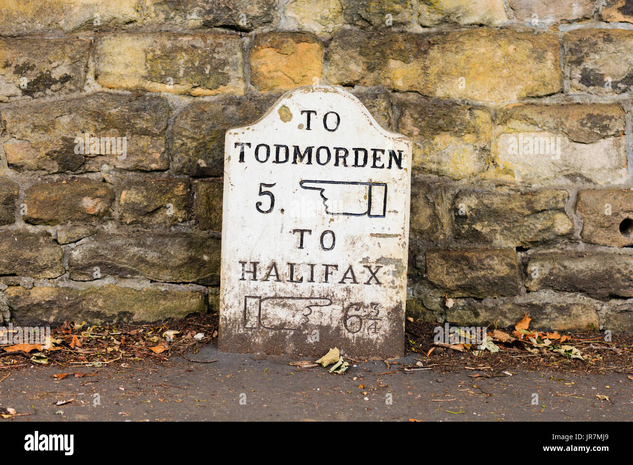 Un tradizionale di pietra pietra miliare marcatore in Haden Bridge, West Yorkshire, Regno Unito Foto Stock