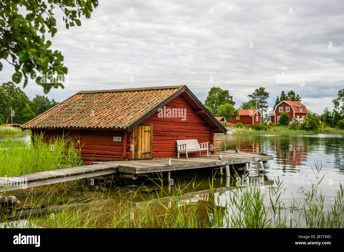 La vecchia darsena con travi di legno con il banco di bugiardi sul ponte nella parte settentrionale dell'arcipelago di Stoccolma, Bjorko-Arholma, Marum Foto Stock