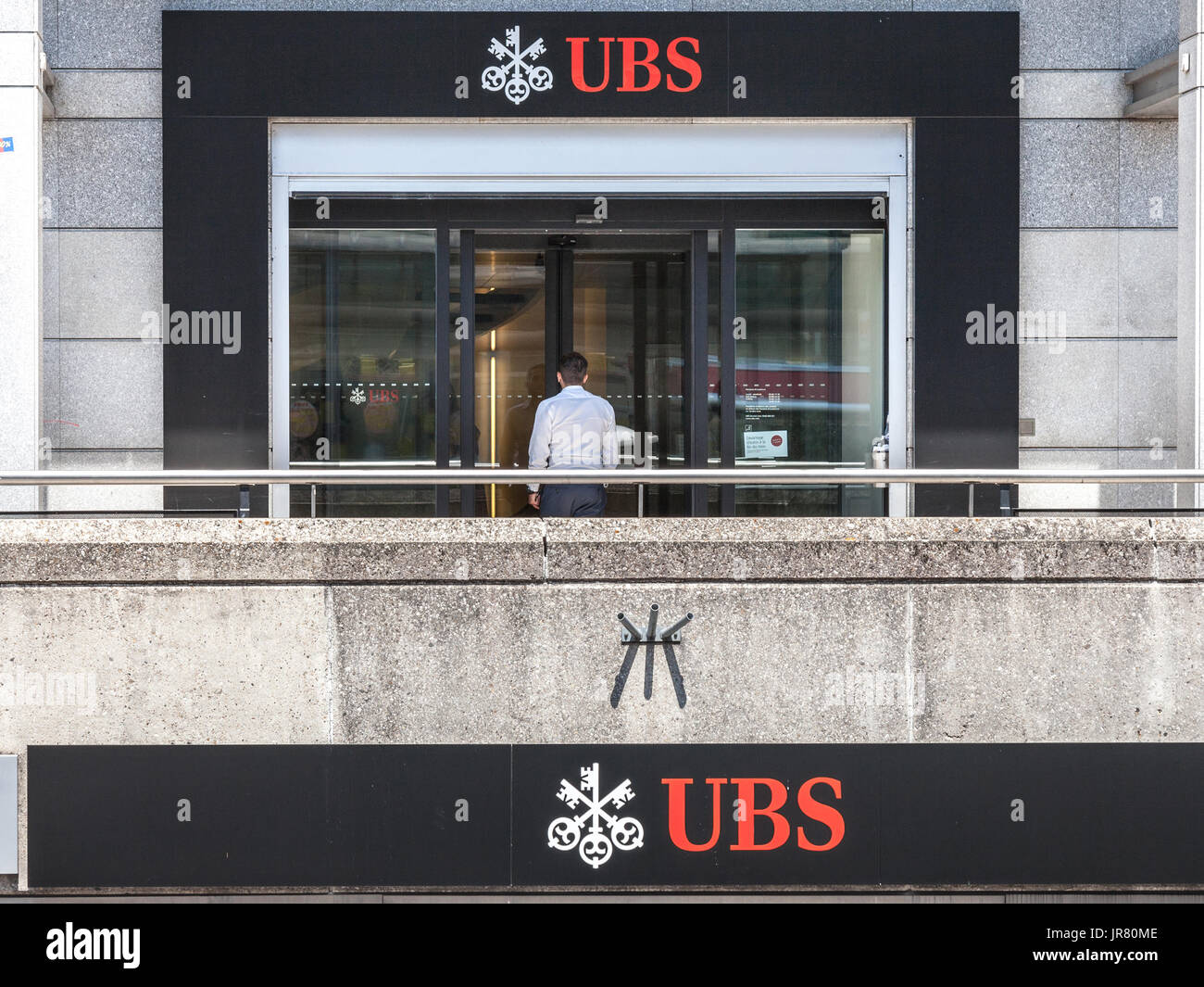 Ginevra, Svizzera - 19 giugno 2017: uomo di entrare in una filiale locale di UBS (Union Bank Svizzera) a Ginevra. UBS è una delle principali banche del paese Foto Stock