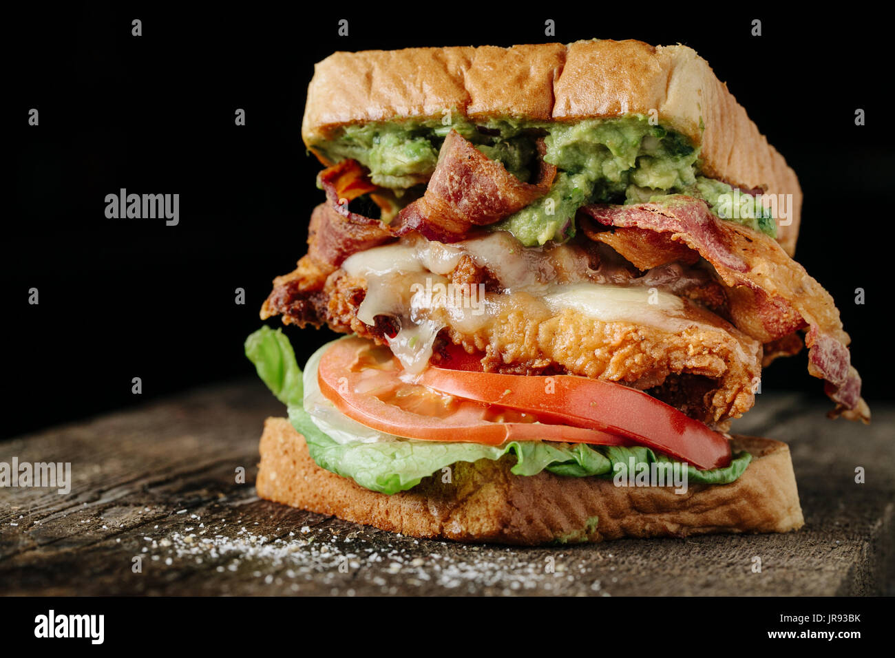Pollo e avocado BLT sandwich su sfondo nero Foto Stock