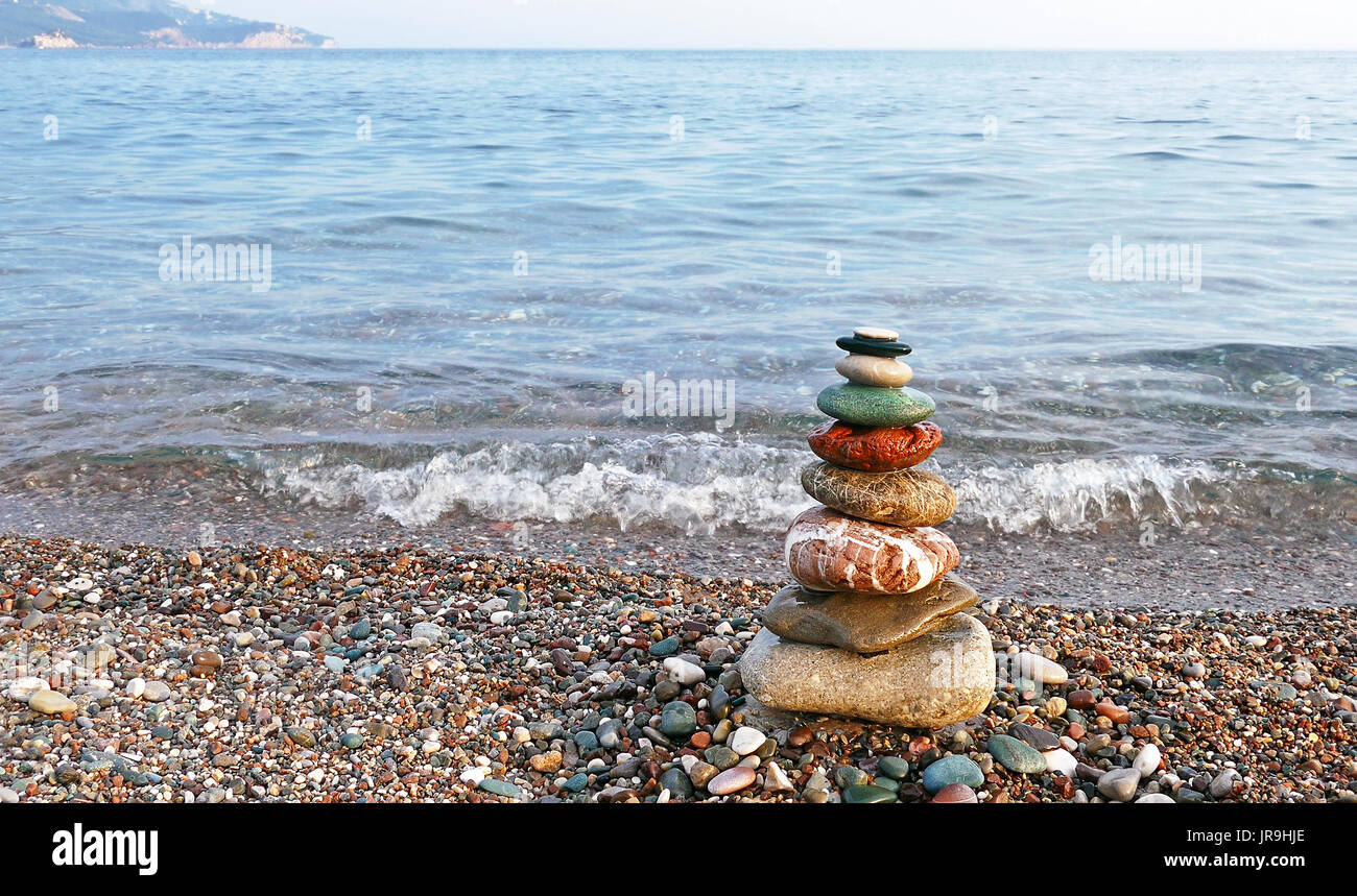 Equilibrio di pietre sulla spiaggia al tramonto. Concetto di pace e di armonia. Foto Stock