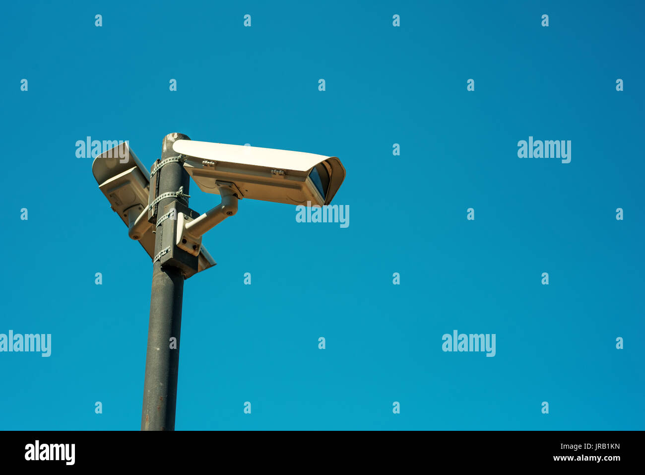 Due videocamere di sicurezza CCTV montato su alte post per la scuola cantiere la sorveglianza e il controllo Foto Stock
