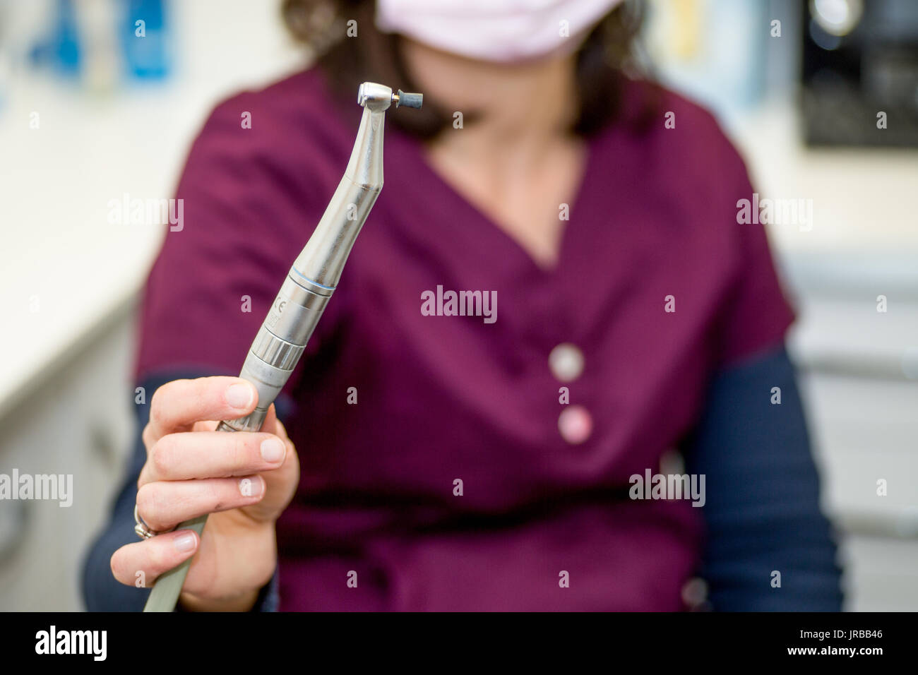 Igienista dentale con tenuta in mano il manipolo con coppa di gomma per la lucidatura dei denti dopo la procedura dentale Foto Stock