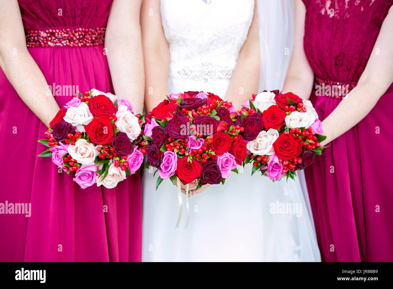 Sposa con bridesmaids holding bouquet nuziali Foto Stock
