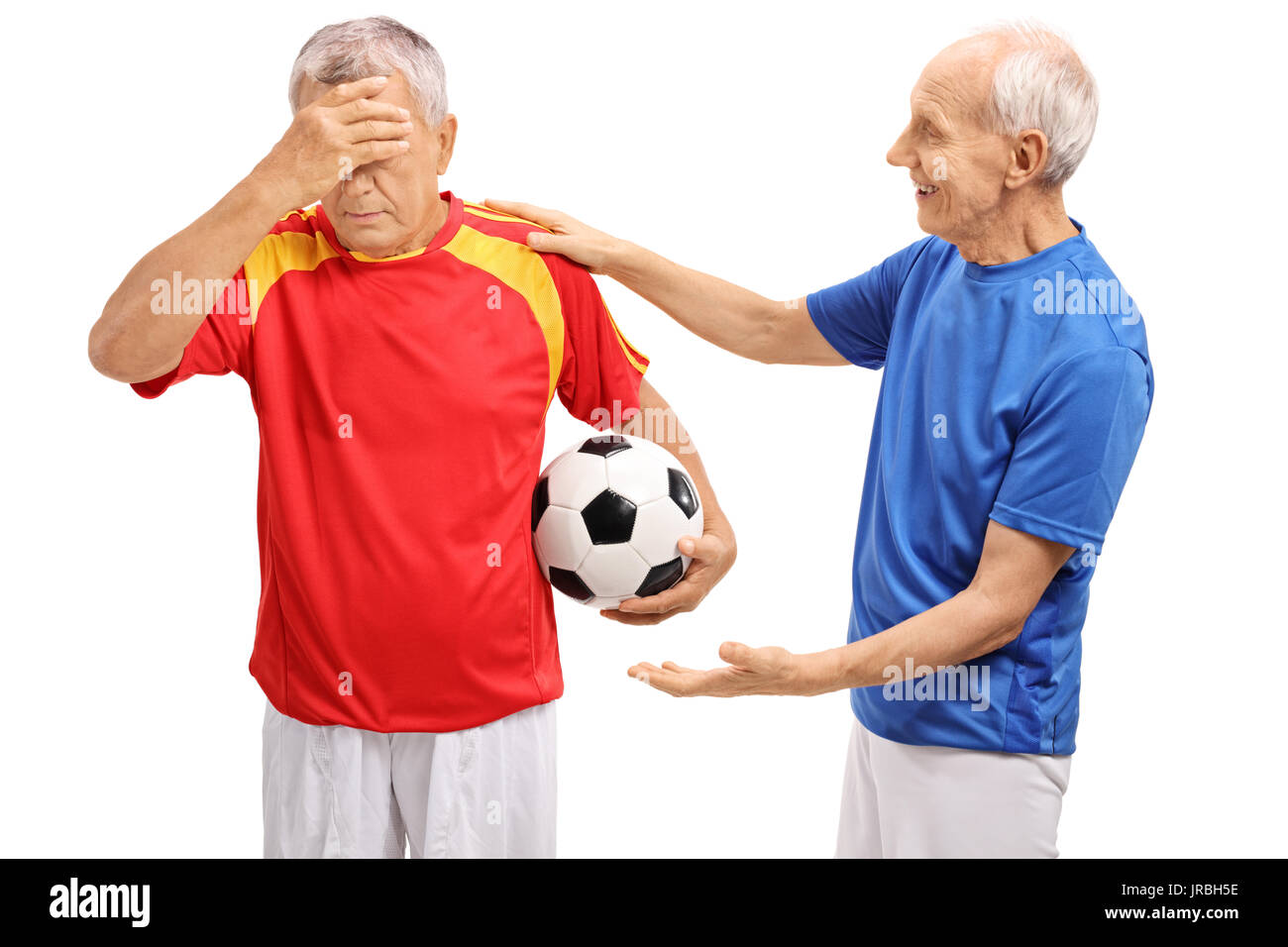 Anziani giocatore di calcio consolante un altro giocatore isolato su sfondo bianco Foto Stock