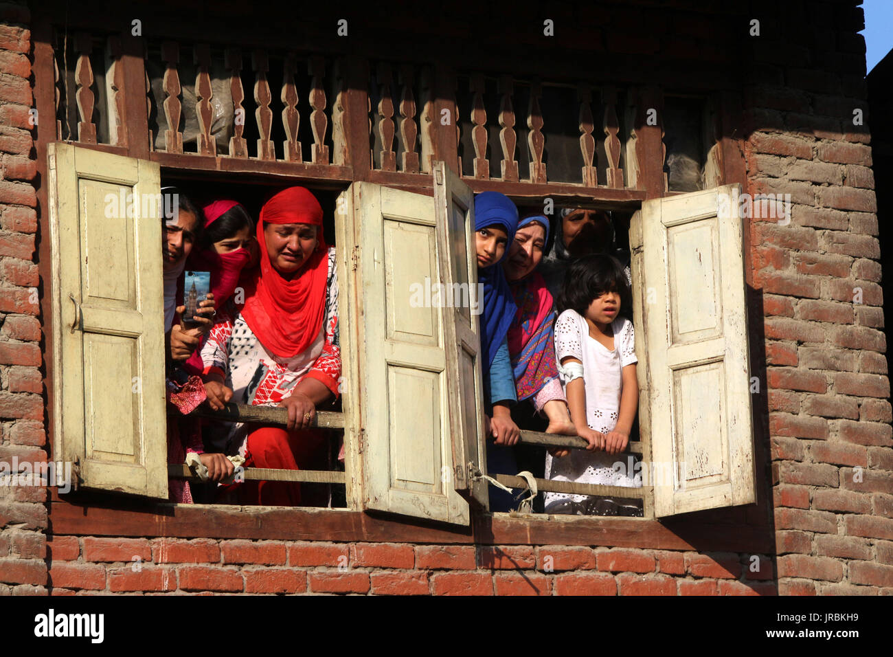 Kashmir le donne musulmane a guardare il corteo funebre da una finestra di un uccisi dai ribelli Hizb Yawar alias Gazi in Hanfia Eidgah Janglatandi in località della città vecchia Anantnag, 55 chilometri a sud di Srinagar. Yawar a 17 giorno ribelle vecchio è stato ucciso nel corso di un incontro con le forze di sicurezza Kanelwan villaggio nella cinghia Dochnipora di Bijbehara nello stesso quartiere di giovedì sera. Altri due ribelli sono riusciti a fuggire dalla zona mentre un civile- Ghulam Muhamad Bhat Arwani dal villaggio di Bijbehara è stato anche ucciso nello scambio di fuoco. (Foto di Muneeb Ul Islam/Pacific Stampa) Foto Stock
