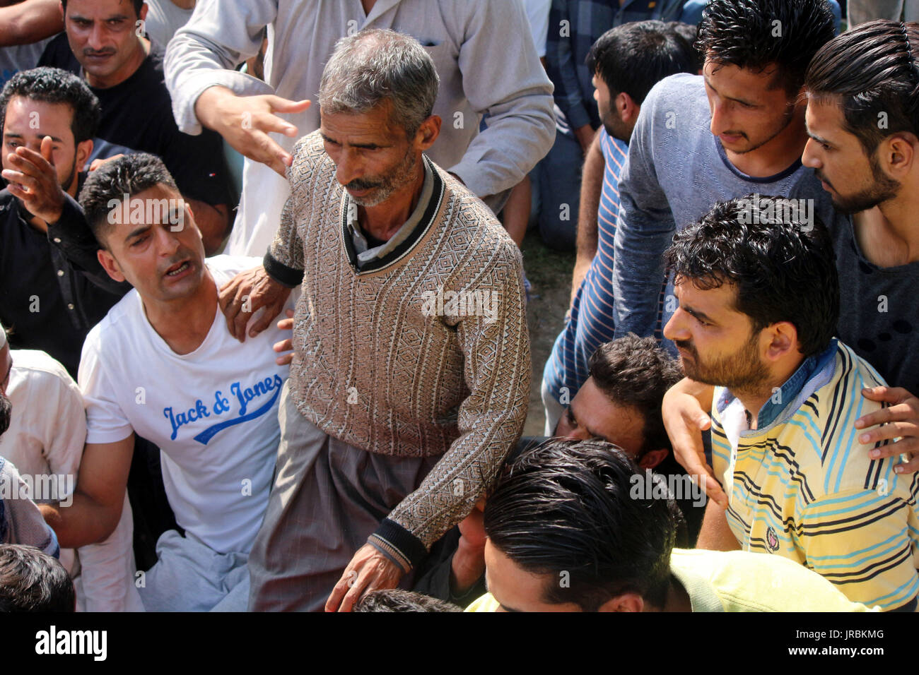 Padre di un uccisi dai ribelli Hizb Yawar alias Gazi guarda verso il corpo morto durante il corteo funebre in Hanfia Eidgah Janglatandi in località della città vecchia Anantnag, 55 chilometri a sud di Srinagar. Yawar a 17 giorno ribelle vecchio è stato ucciso nel corso di un incontro con le forze di sicurezza Kanelwan villaggio nella cinghia Dochnipora di Bijbehara nello stesso quartiere di giovedì sera. Altri due ribelli sono riusciti a fuggire dalla zona mentre un civile- Ghulam Muhamad Bhat Arwani dal villaggio di Bijbehara è stato anche ucciso nello scambio di fuoco. (Foto di Muneeb Ul Islam/Pacific Stampa) Foto Stock