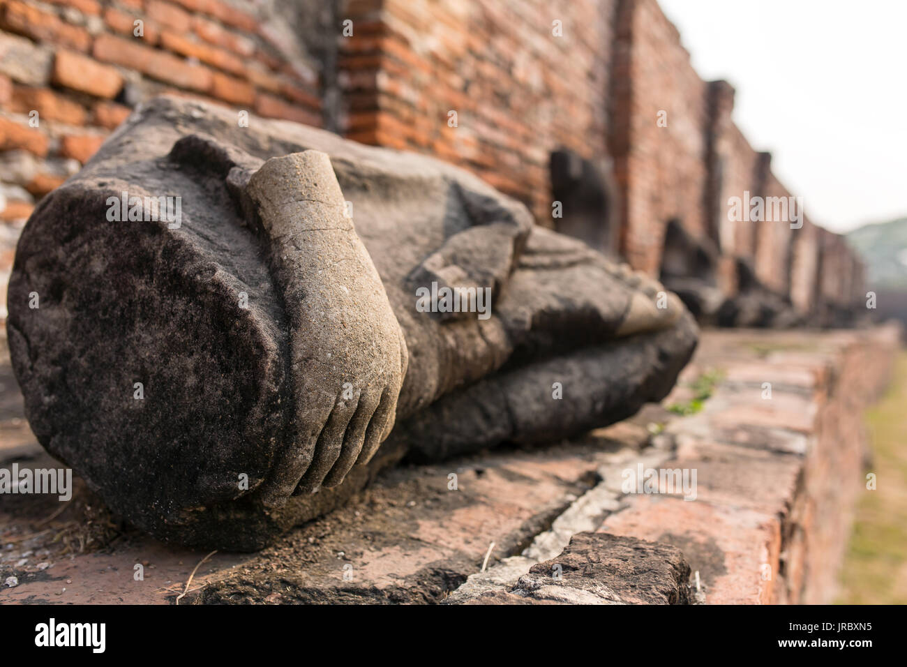 Dettaglio di molti decapitati Buddha lungo una parete del tempio di Wat Mahathat, tempio della grande reliquia, in Ayutthaya, Thailandia Foto Stock