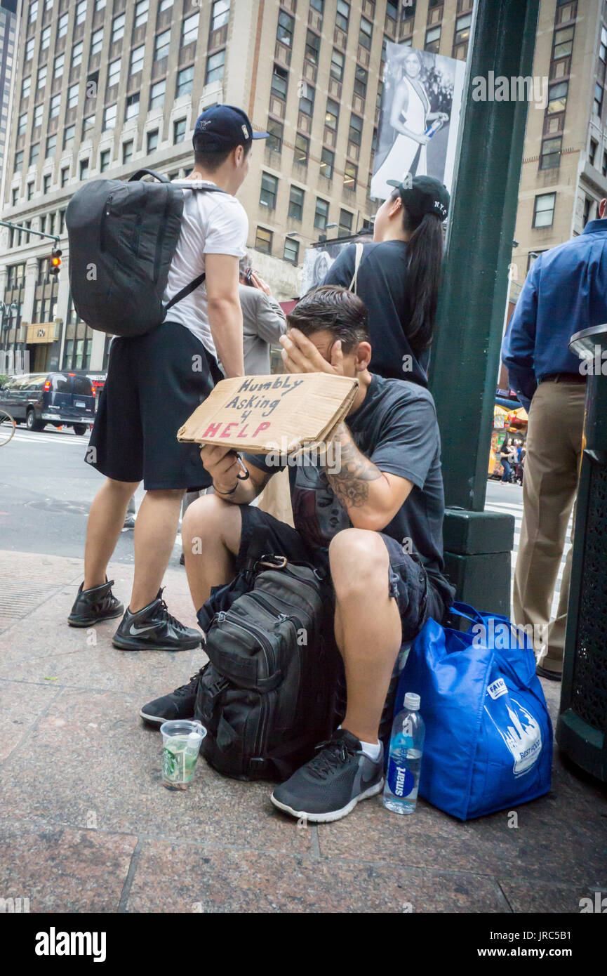 Un individuo di accattonaggio in Midtown Manhattan a New York il giovedì, 27 luglio 2017. (© Richard B. Levine) Foto Stock