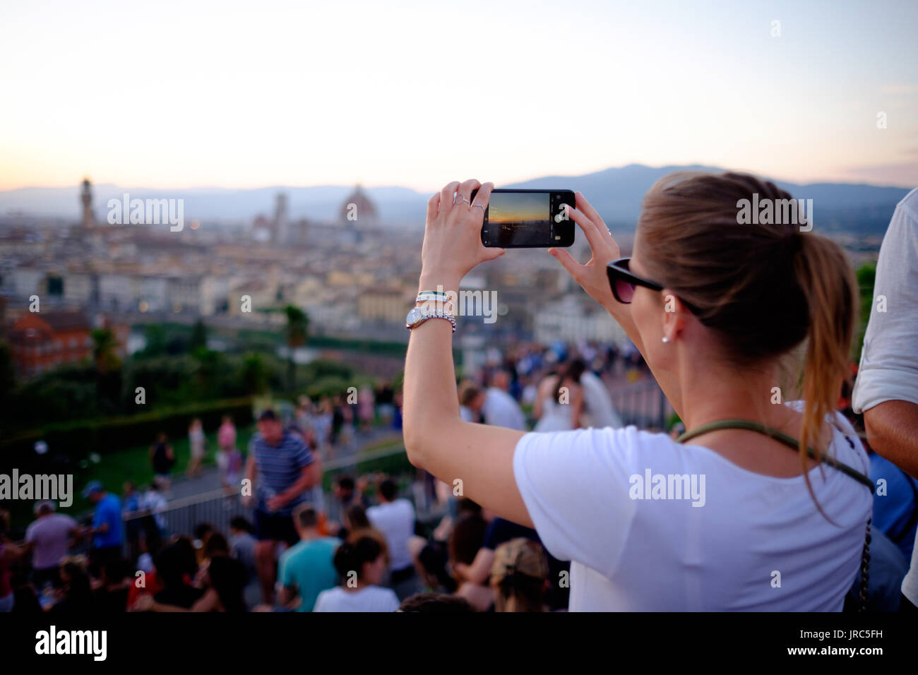 Una ragazza prende una fotografia che si affaccia su Firenze Italia Foto Stock