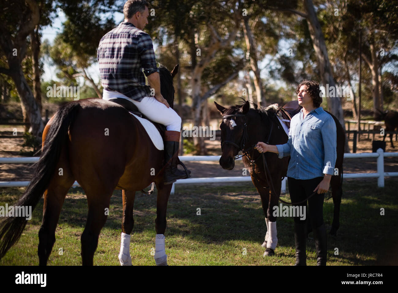 Due amici maschi interagire gli uni con gli altri in un ranch in una giornata di sole Foto Stock