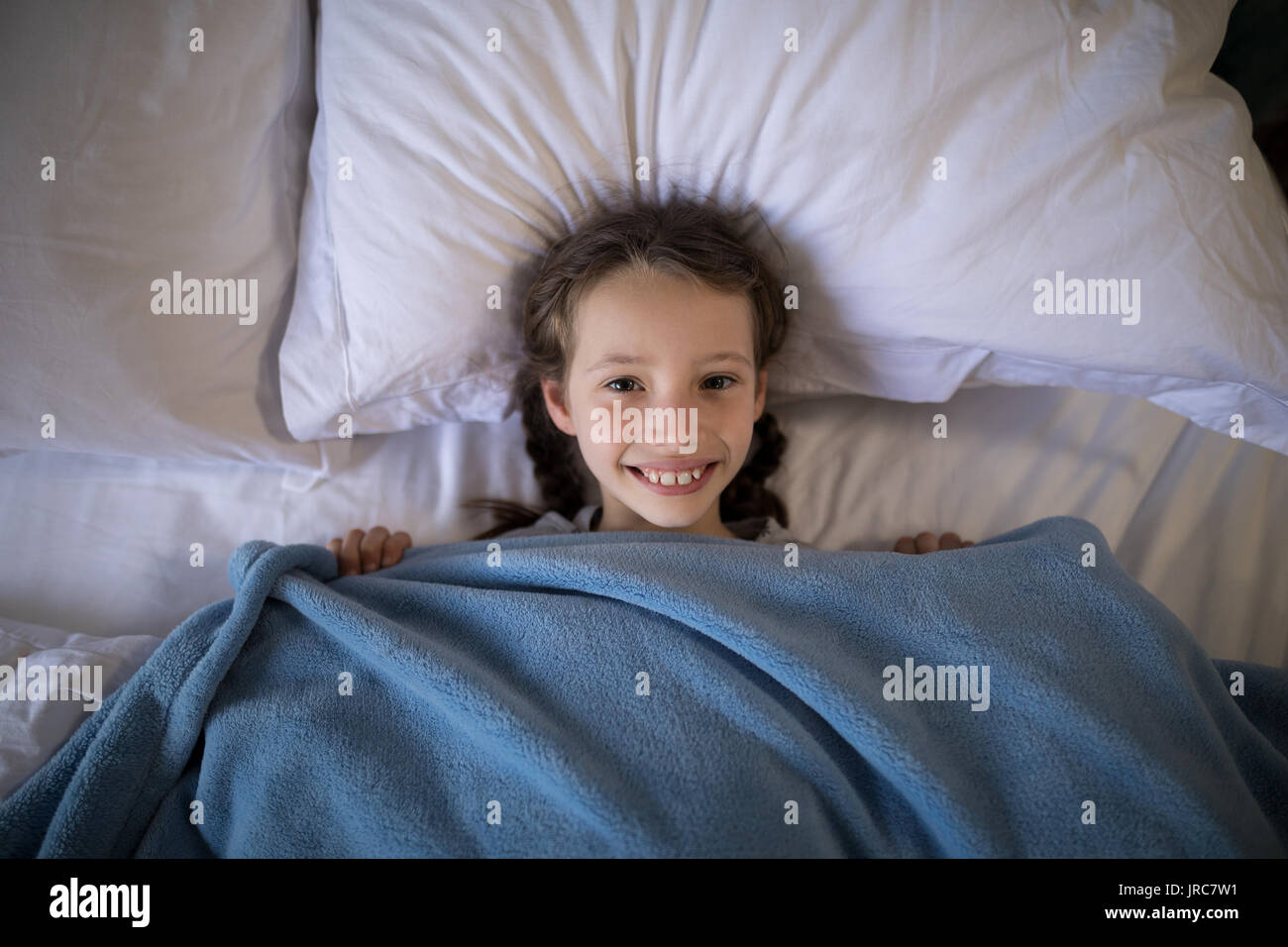 Ritratto di ragazza sorridente sdraiato sul letto in camera da letto Foto Stock