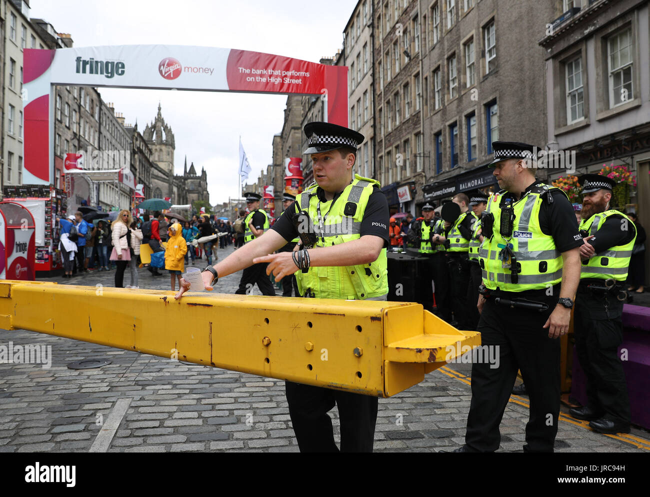 Un funzionario di polizia si apre una porta di sicurezza sul Royal Mile di Edimburgo, come la festa principale stagione ufficialmente si mette in modo in un anno fondamentale nella vita culturale della città. Foto Stock