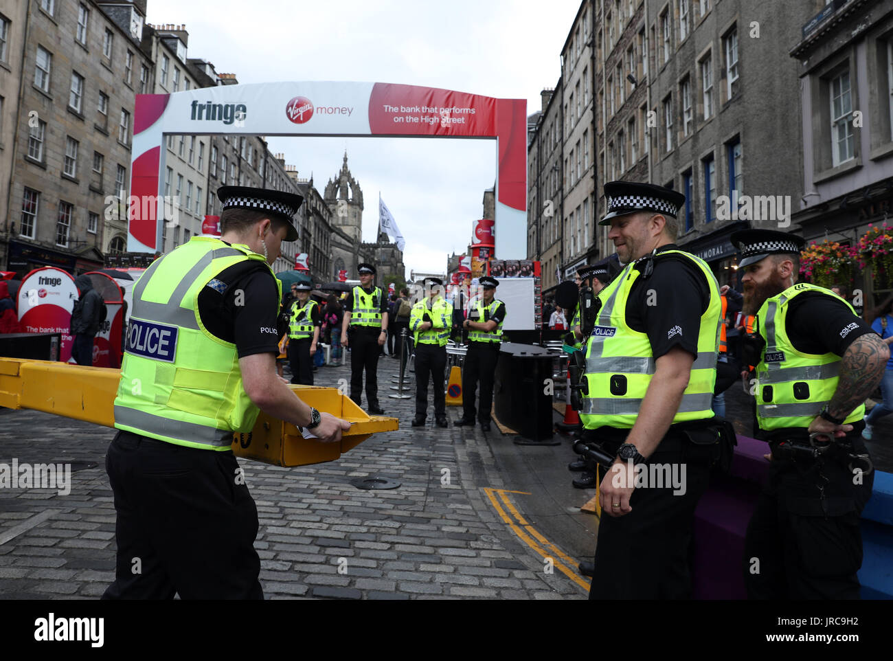 Un funzionario di polizia si apre una porta di sicurezza sul Royal Mile di Edimburgo, come la festa principale stagione ufficialmente si mette in modo in un anno fondamentale nella vita culturale della città. Foto Stock