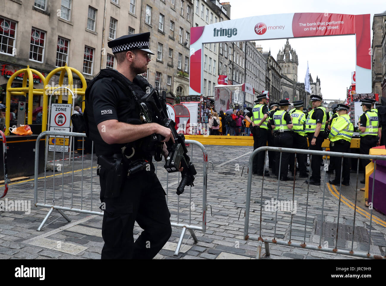 Un agente di polizia armato a dovere sul Royal Mile di Edimburgo, come la festa principale stagione ufficialmente si mette in modo in un anno fondamentale nella vita culturale della città. Foto Stock