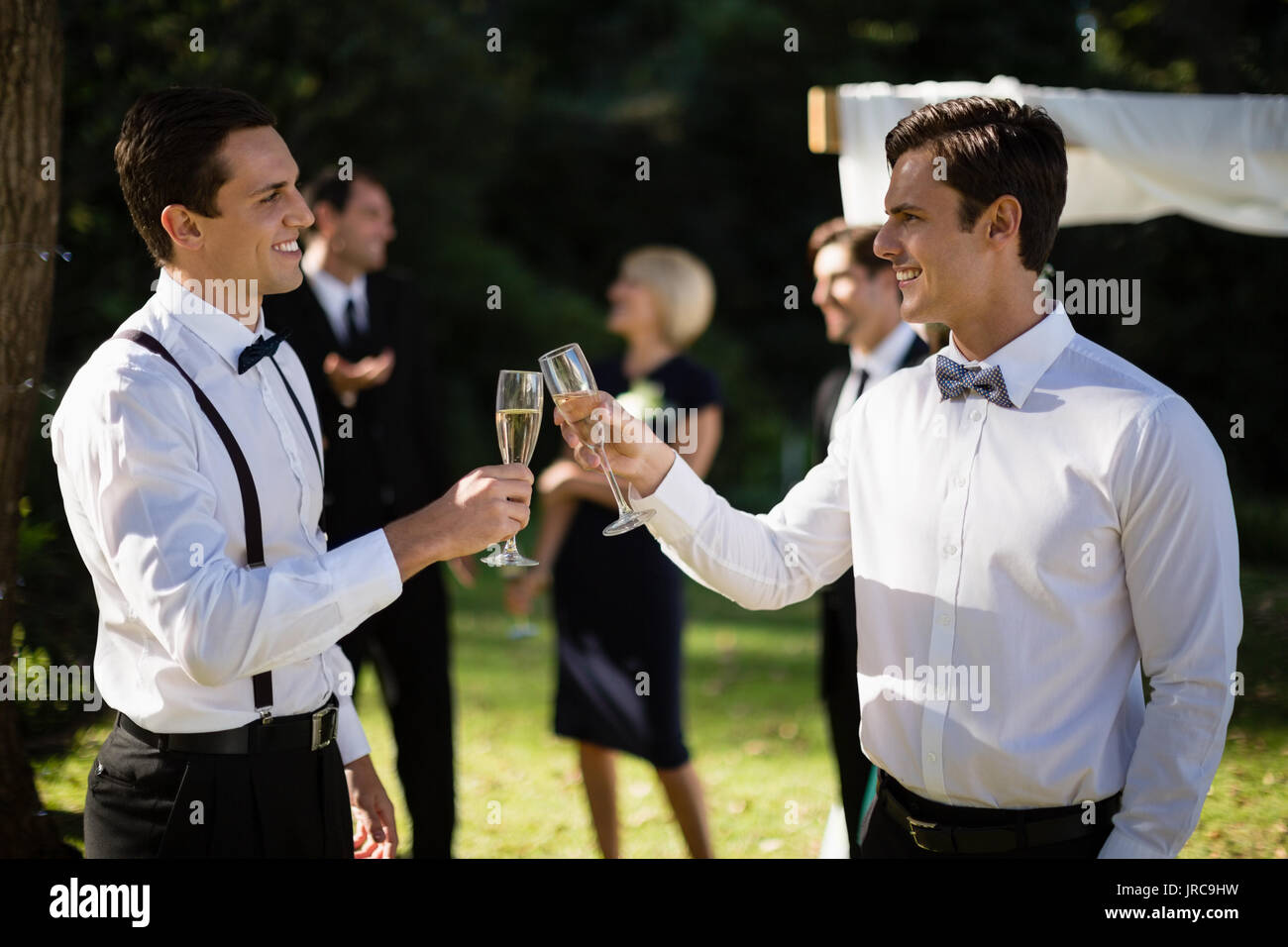 I camerieri champagne di tostatura in park durante il matrimonio Foto Stock