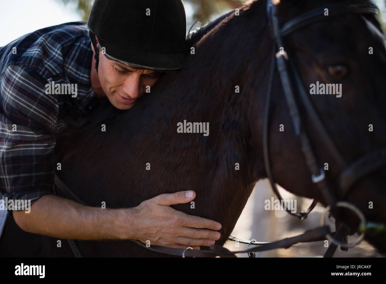Jockey maschio di equitazione nel ranch in una giornata di sole Foto Stock