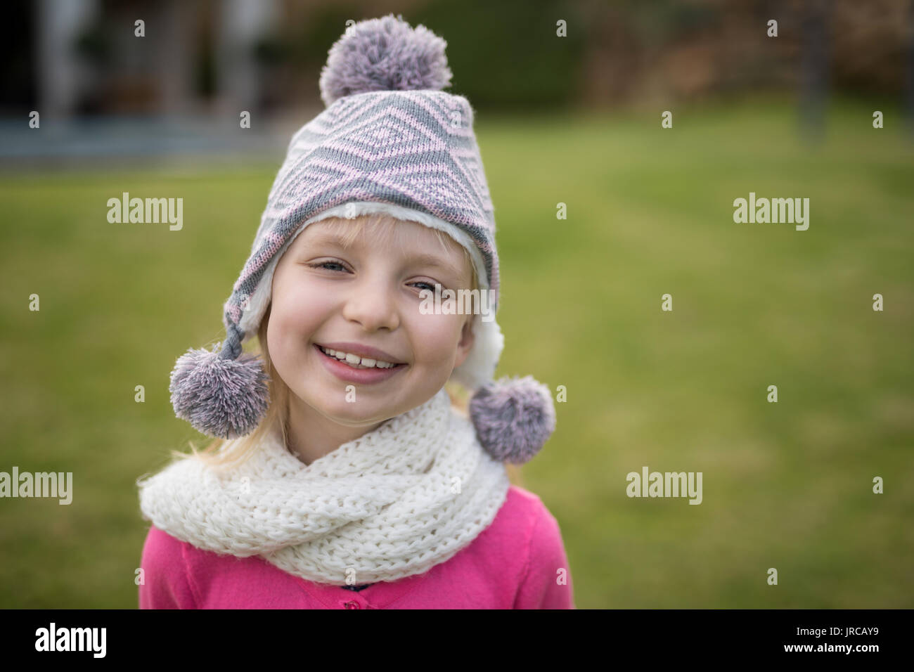 Ritratto di ragazza sorridente in piedi in giardino Foto Stock