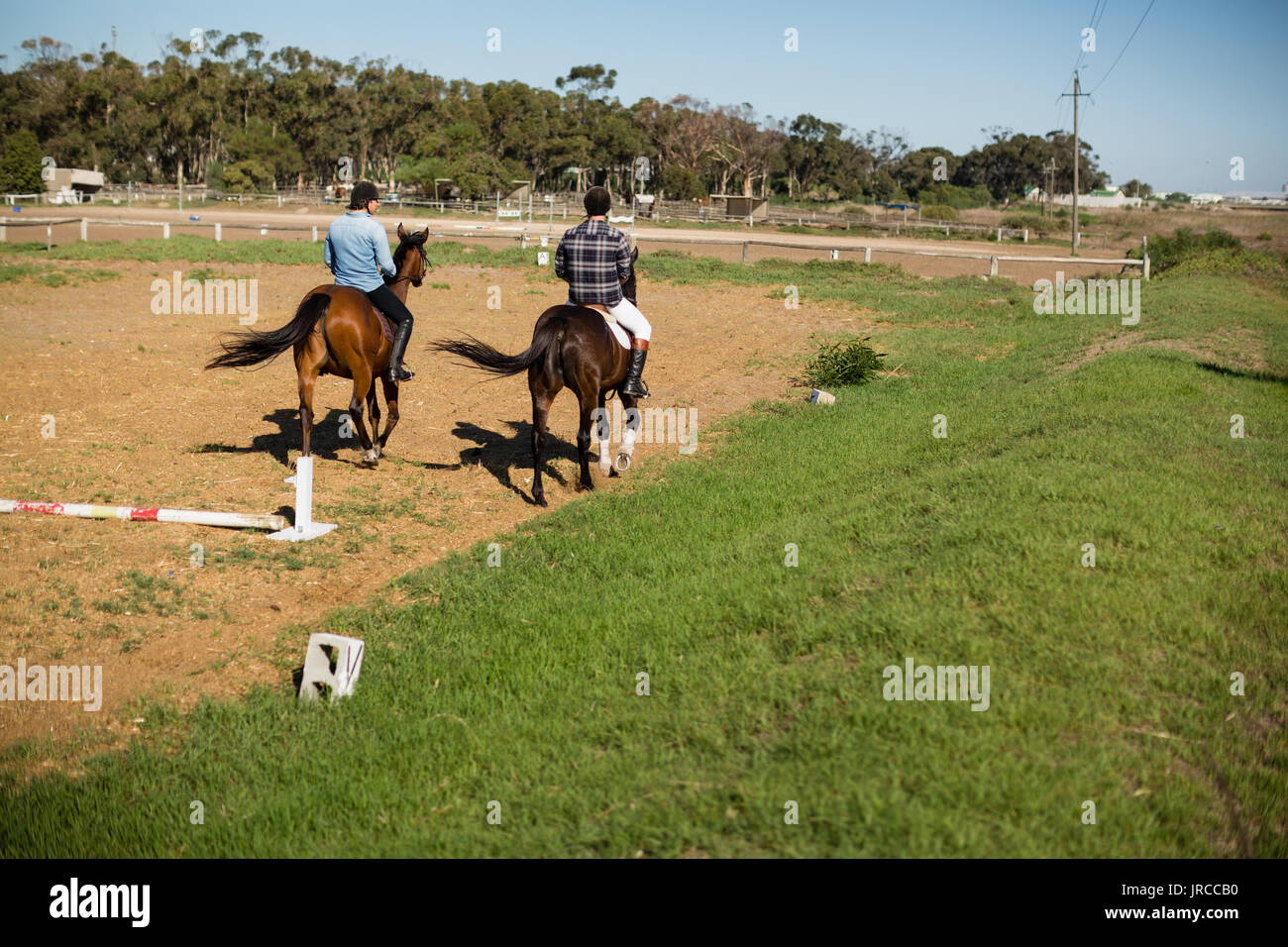 Due amici maschi a cavallo in un ranch in una giornata di sole Foto Stock